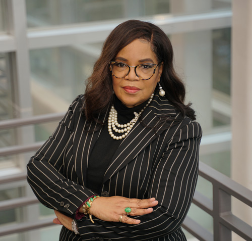 Dr. Carolyn Lightfoot stands on a stairwell, arms crossed