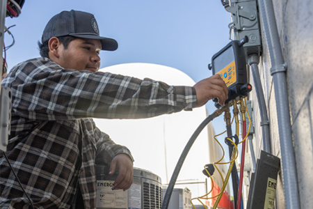 An HVAC technician works on a unit