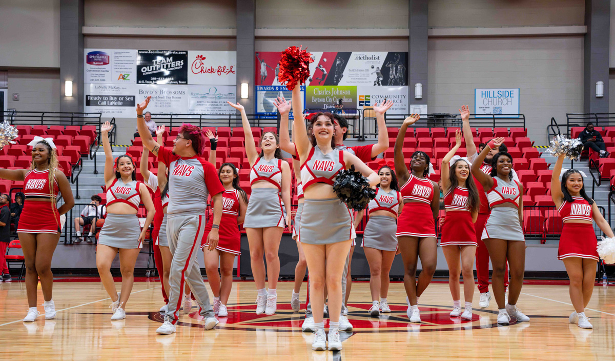 A group of about 15 cheerleaders cheer in the arena