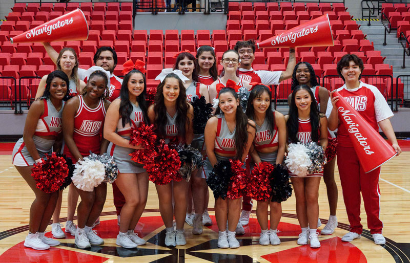 A group of 15 cheerleaders pose for a photo in the arena.