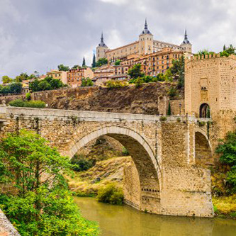 A castle on a mountain in the background, and a bridge in the foreground